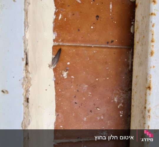 אריחים חומים עם לכלוך בין מסגרות מתכת חלודות